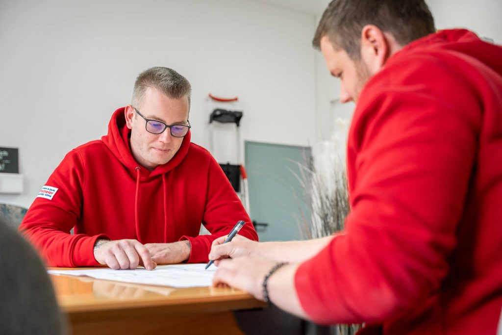 Konzentriertes Fachgespräch über technische Zeichnung am Besprechungstisch