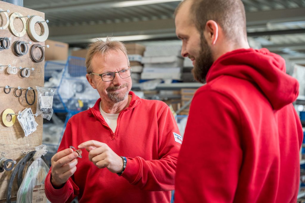 Zwei Hermsmeier Techniker besprechen Kupferfittings im Ersatzteillager